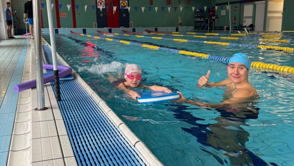 Grzegorz trener uczy dzieci pływać
